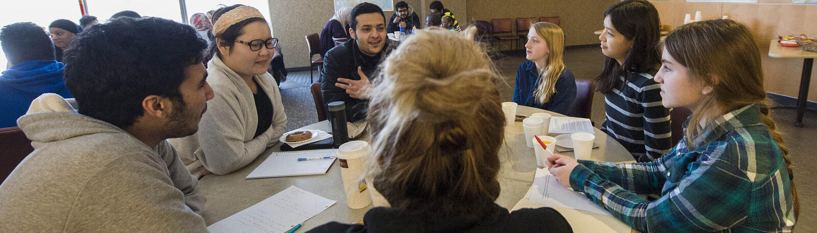 photo of students sitting at a table and talking
