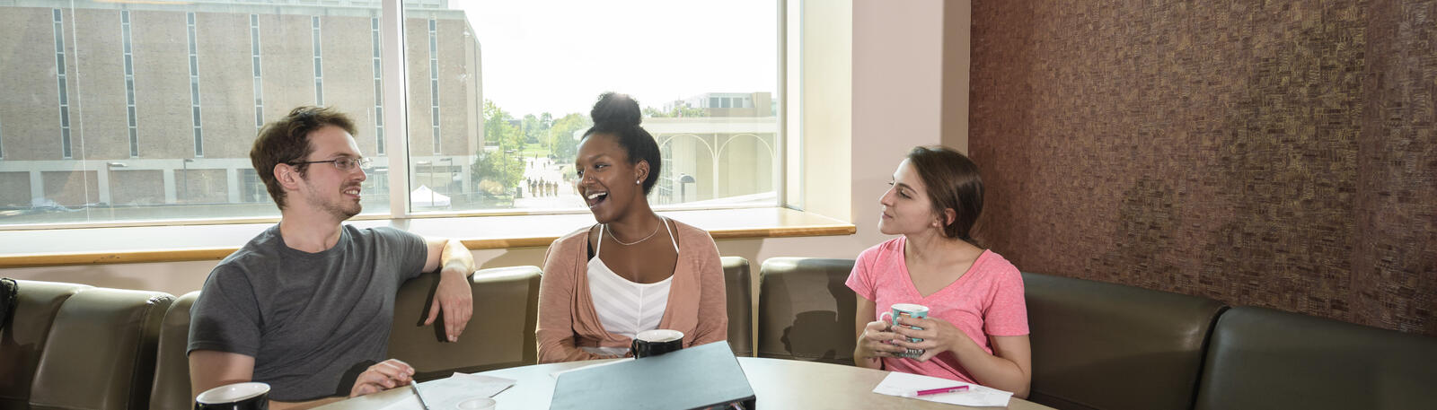 photo of students sitting at a table and talking
